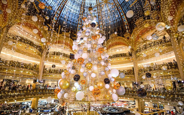 Cây thông Noel khổng lồ được đặt dưới mái vòm trong trung tâm thương mại Galeries Lafayette ở Paris, Pháp.