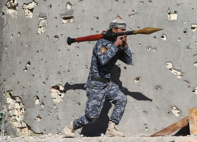 Thành viên của lực lượng an ninh Iraq vác súng phóng rocket đi qua thị trấn Husayba trong cuộc chiến chống phiến quân Nhà nước Hồi giáo (IS).