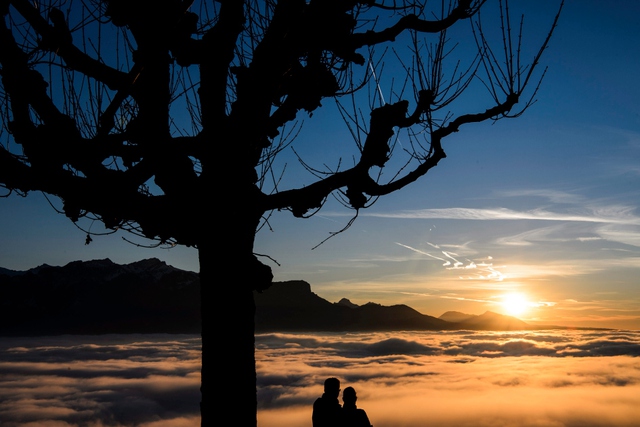 Cặp tình nhân ngắm cảnh hoàng hôn trên màn mây bao phủ hồ Geneva ở Chardonne, Thụy Sĩ.