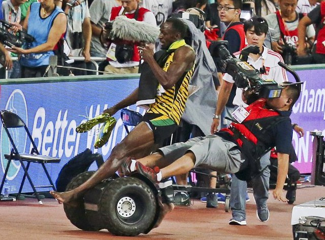 
Cảnh tượng lộn xộn khi vận động viên Usain Bolt của Jamaica bị một nhân viên quay phim đi trên một chiếc xe Segway di chuyển chậm tông lúc đang ăn mừng sau khi về nhất cự li 200m tại Giải điền kinh vô địch thế giới tổ chức tại Bắc Kinh, Trung Quốc ngày 27-8.
