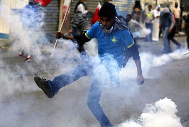 Người biểu tình đá lựu đạn hơi cay trả lại cảnh sát chống bạo động ở Bilad Al Qadeem, gần Manama, Bahrain.