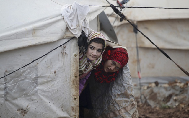ác cô gái nhìn ra ngoài từ túp lều của họ trong trại tị nạn Al-Karameh ở Northern Idlib, Syria.