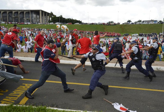 Những người biểu tình đụng độ với cảnh sát chống bạo động trước tòa nhà quốc hội ở thủ đô Brasilia, Brazil.