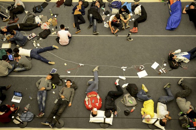 Mọi người ngủ trên đường phố trong khi xếp hàng chờ lễ khai trương của một cửa hàng Apple Store tại thành phố Hàng Châu, Trung Quốc.