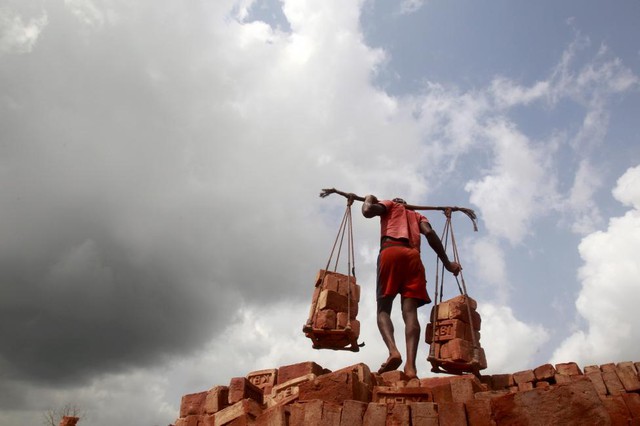 Người lao động gánh gạch tại một nhà máy gạch ở ngoại ô Agartala, Ấn Độ.