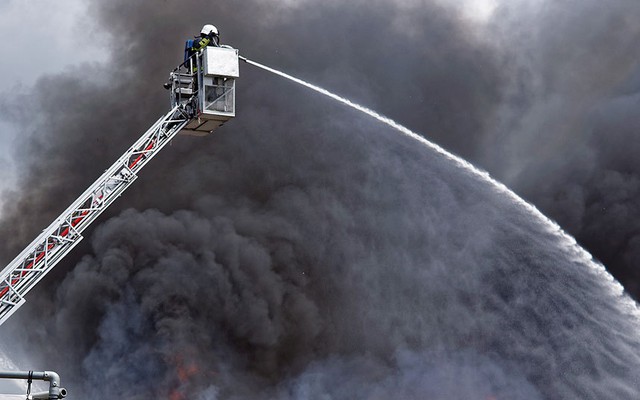 Lính cứu hỏa cố gắng dập tắt đám cháy bùng phát tại nhà máy Lotus ở thành phố Wolvertem, Bỉ.