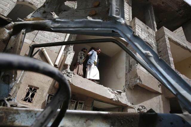 Người dân kiểm tra ngôi nhà bị phá hủy trong đợt không kích của liên minh Ả-rập nhằm vào thành phố Sanaa, Yemen.