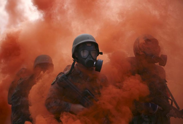 Sinh viên mặc quân phục và đeo mặt nạ phòng khí độc tham gia buổi diễn tập quân sự đặc biệt ở Bắc Kinh, Trung Quốc.