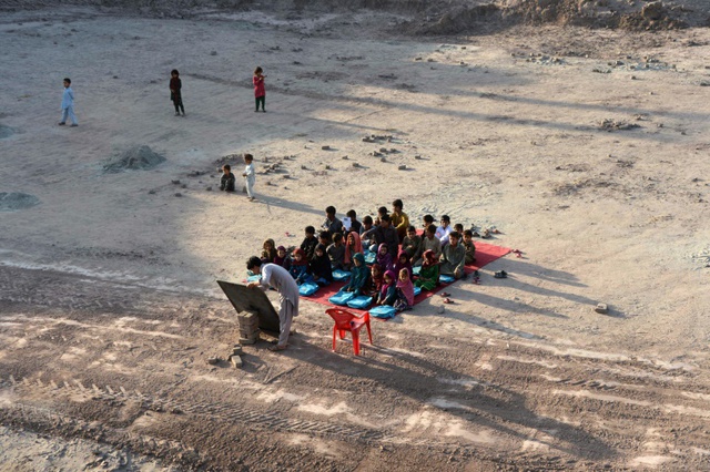 Những em học sinh Afghanistan tham gia vào một lớp học ngoài trời bên ngoài nhà máy gạch ở ngoại ô Jalalabad.