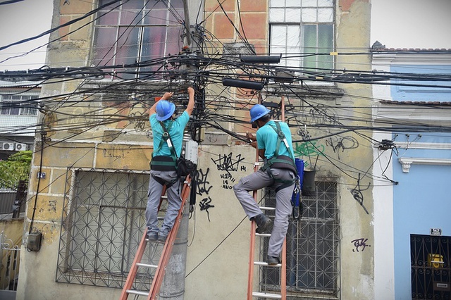 Các công nhân sửa đường dây điện thoại được mắc chằng chịt trên đường phố ở Rio de Janeiro, Brazil.