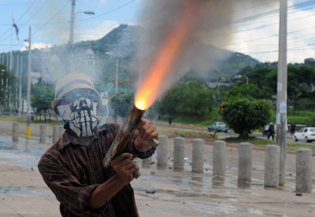 Sinh viên bắn súng tự chế vào cảnh sát trong cuộc biểu tình tại thành phố Tegucigalpa, Honduras.