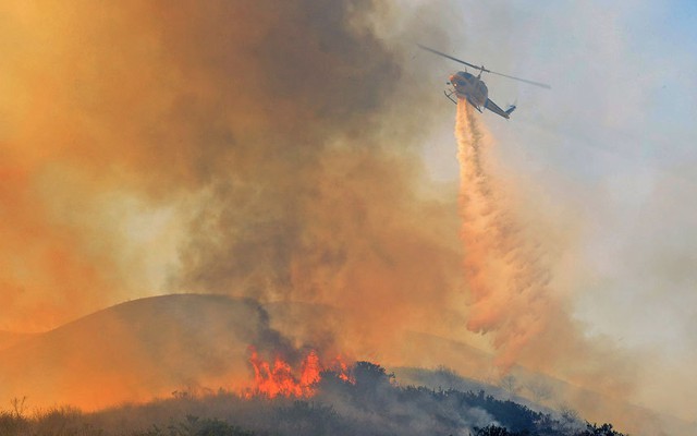 Máy bay trực thăng thả nước để dập tắt một đám cháy rừng tại Ventura, bang California, Mỹ.