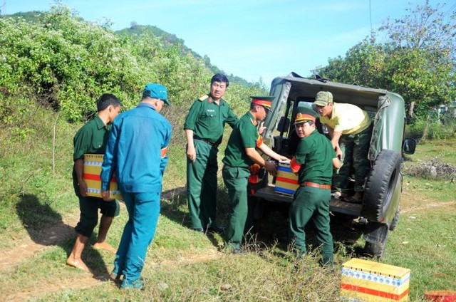 
Lực lượng chức năng xếp các thùng chứa đầu đạn lên xe mang đi tiêu hủy. Ảnh: Lâm Thiên
