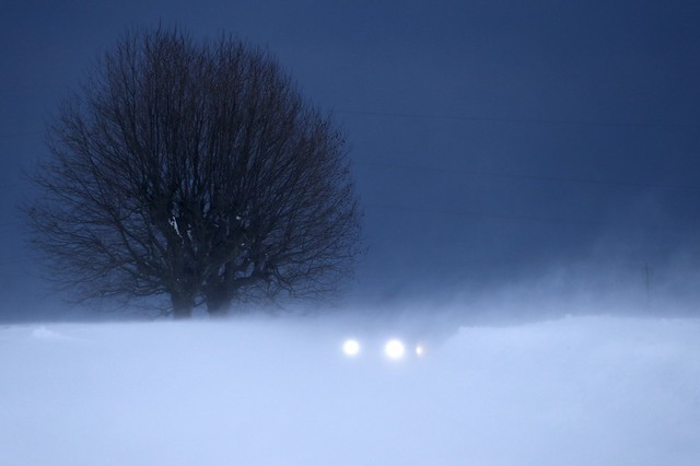 Một chiếc ô tô đi qua bão tuyết ở Lausanne, Thụy Sĩ.