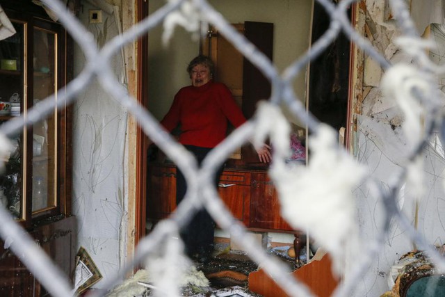 Phản ứng của người phụ nữ khi nhìn đống đổ nát trong căn hộ của mình bị phá hủy bởi đạn pháo ở thị trấn Yenakieve, miền đông Ukraine.