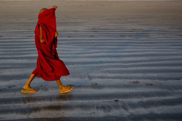 Một nhà sư đi trên bãi biển ở Ngwe Saung-gauk, Myanmar.