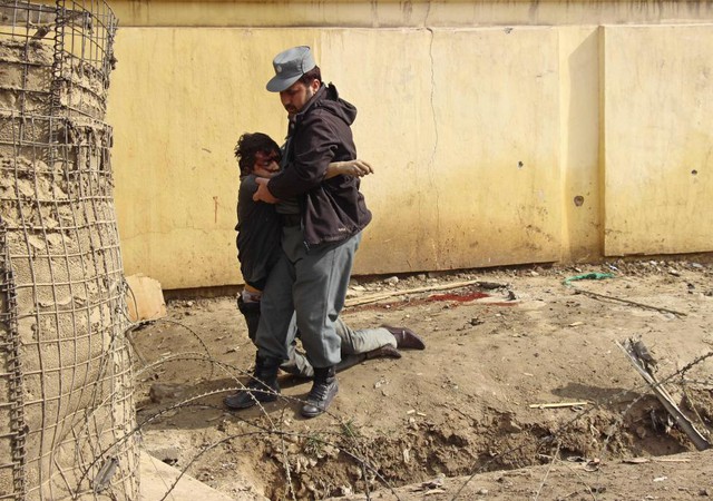 Cảnh sát giúp đỡ một đồng nghiệp bị thương trong vụ đánh bom tự sát ở tỉnh Kunduz, Afghanistan.