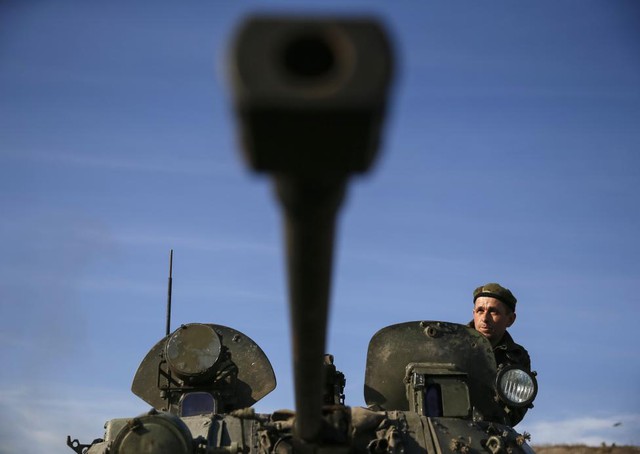 Một binh sĩ Ukraine nhìn ra ngoài từ chiếc xe bọc thép tại một điểm chốt ở Kurakhovo, Donetsk, miền đông Ukraine.