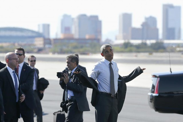 Tổng thống Mỹ Barack Obama mắc áo khoác trước khi lên chuyên cơ Air Force One tại sân bay quốc tế Phoenix Sky Harbor ở Phoenix để trở về thủ đô Washington.