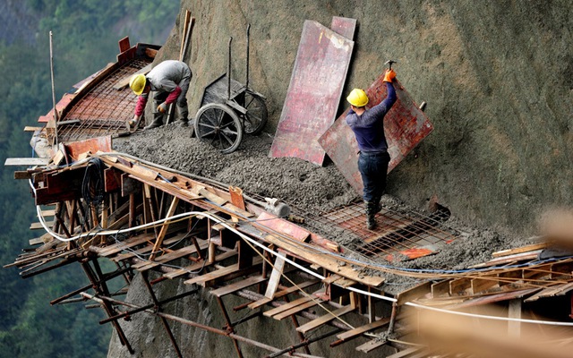 Công nhân làm việc tại công trường dựng đường trên sườn núi ở Bình Giang, tỉnh Hồ Nam, Trung Quốc.