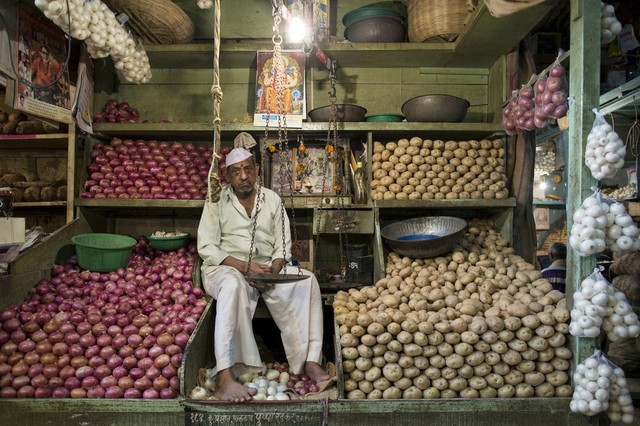 Người bán hàng chờ khách tại gian hàng của mình trong một khu chợ ở Mumbai, Ấn Độ.