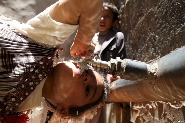 Một bé gái uống nước từ đường ống nước máy khi tình trạng thiếu nước sạch nghiêm trọng xảy ra tại thành phố Sanaa, Yemen.