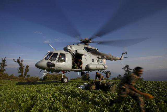 Quân nhân Nepal nhảy khỏi một chiếc trực thăng của Ấn Độ để phân phát hàng cứu trợ có các nạn nhân động đất trên đỉnh một quả đồi ở Dolkha.