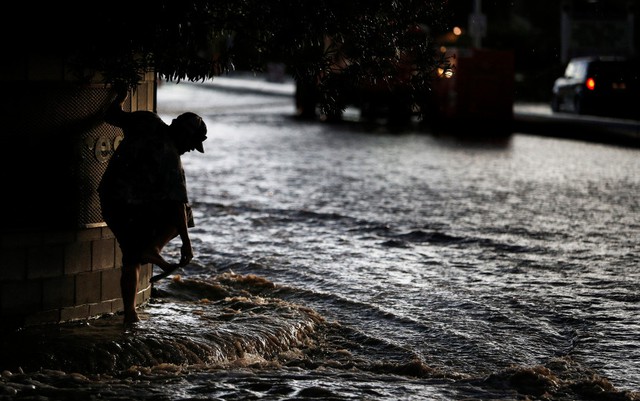 Người đàn ông đang tìm cách lội qua đường phố ngập lụt ở Las Vegas, Mỹ.