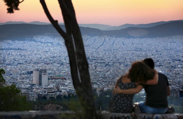 Cặp tình nhân ngồi ngắm hoàng hôn từ đồi Lycabettus ở Athens, Hi Lạp.