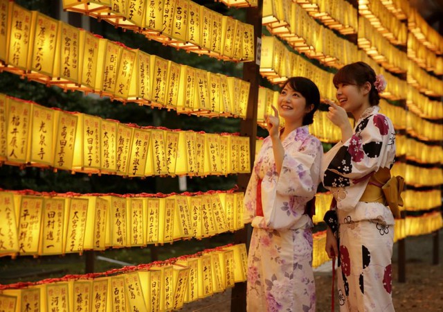 Hai thiếu nữ mặc trang phục kimono truyền thống đứng ngắm đèn lồng tại lễ hội Mitama Matsuri ở ngôi đền Yasukuni ở Tokyo, Nhật Bản.