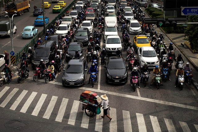 Người bán vải đẩy xe qua đường phố đông đúc Bangkok, Thái Lan.