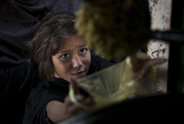 Bé gái nhận đồ ăn cho gia đình mình tại một trung tâm phân phát thực phẩm miễn phí ở Islamabad, Pakistan.