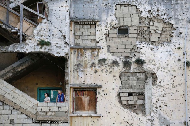 Trẻ em tị nạn người Syria đứng trên cầu thang của một tòa nhà chung cư bị phá hủy bởi bom đạn ở Beirut, Li Băng.