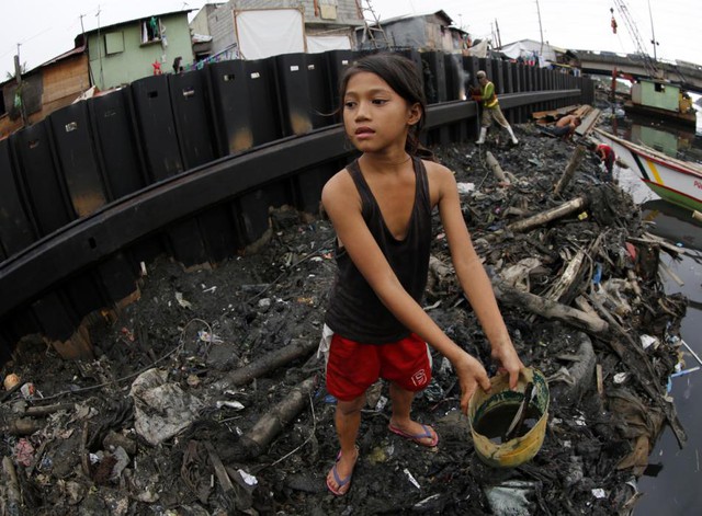 
Bé gái nhặt rác tái chế gần một con đập chắn sóng đang được xây dựng tại thành phố Paranaque, Philippines.

