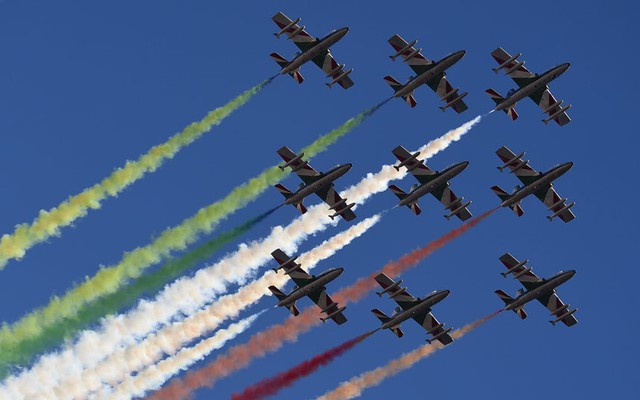 Phi đội Frecce Tricolori của Không quân Italia phụt khói màu tạo thành cờ Italia trên bầu trời thành phố Alta Badia.