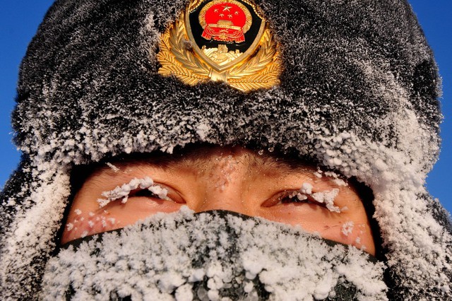 Băng tuyết phủ kín khuôn mặt một người cảnh sát ở làng Beiji, miền đông bắc Trung Quốc.