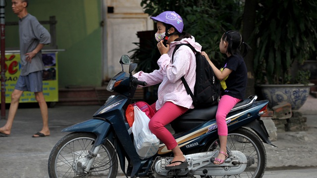 Hiện tượng chở trẻ không mũ bảo hiểm phổ biến vào giờ đưa trẻ đến trường trên phố Mạc Thái Tổ.