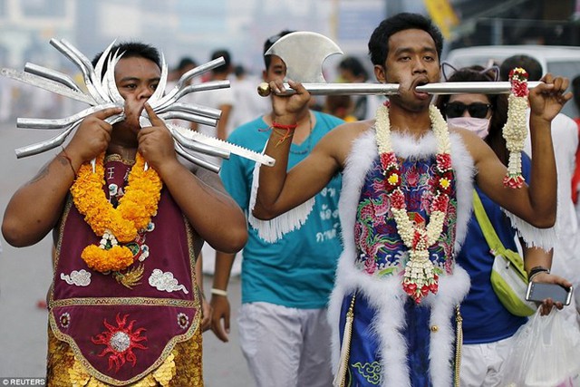 Trong khuôn khổ lễ hội được tổ chức vào tháng 9 âm lịch hàng năm tại đây, thường có các thầy cúng lập đàn gọi hồn cũng như nhiều người dân dâng những loại lễ vật đa dạng. Trong ảnh, hai người đàn ông, trong đó có một người cầm rìu, đang đi bộ trên đường phố Phuket.