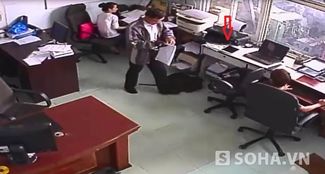 Người đàn ông tự xưng là nhân viên chuyển phát nhanh vào văn phòng công ty Bùi Nguyễn phát tờ báo giá. Chiếc chiếc ipad (mũi tên đỏ) để trên bàn.