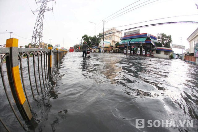 Một người đi bên làn giành cho xe hai bánh nước ngập sâu tắt máy nên phải dắt bộ