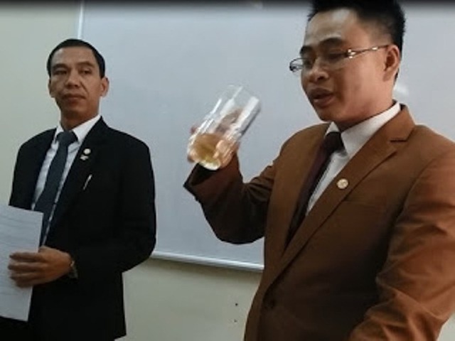 Ông Nguyễn Văn Tâm (người cầm cốc nước hòa từ chai phân bón). Ảnh cắt từ video.