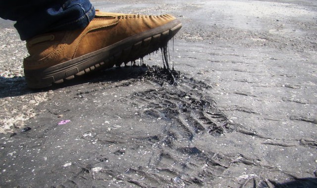 Cảnh tượng này xảy ra tại đường Nguyễn Du (P. Nguyễn Du, TP. Hà Tĩnh). Nhựa đường chảy, dính vào giày của người đi đường. (Ảnh: Văn Định/ Tuổi Trẻ)