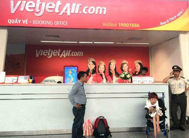 Chị Vân (ngồi xe lăn) ngồi chờ ở sân bay Đà Nẵng vì bị Vietjet từ chối vận chuyển. (Ảnh chị Vân cung cấp)