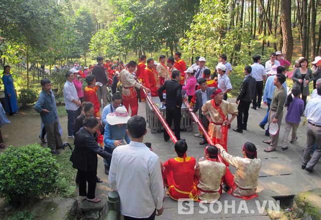 Dọc đường lên khu mộ, nhiều du khách đi lễ cũng tham gia vào việc khiêng cặp bánh chưng này.