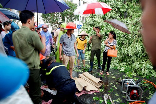 Một người đàn ông khi đi xe máy qua ngã tư Quang Trung - Nguyễn Du thì bất ngờ cây xà cừ lớn bật gốc, đè trúng khiến nạn nhân tử vong tại chỗ. Ảnh: Tiền phong