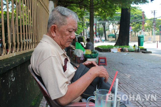 
Nghệ sĩ Mạc Can ngồi ở quán cafe ven đường, nơi ông vẫn thường lui tới.
