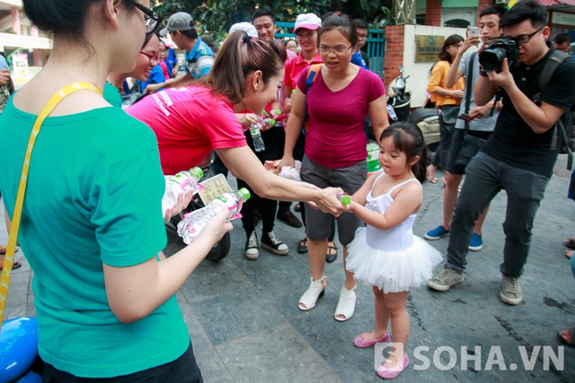 Một em nhỏ tỏ ra rất thích thú khi được Hoa hậu trao tận tay chai nước mát.