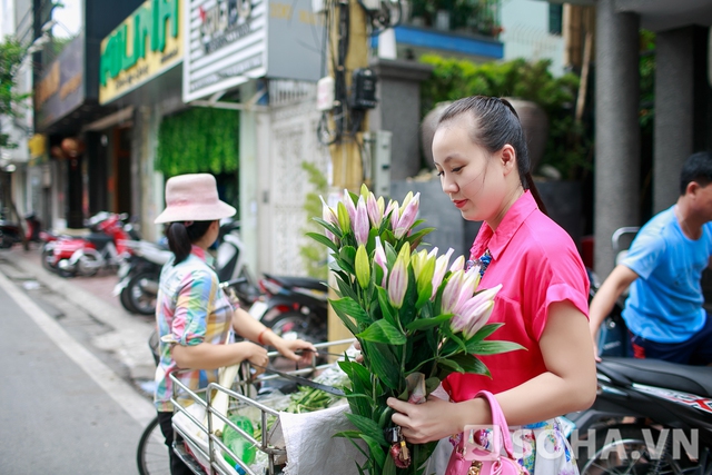 Đi chợ xong, chị di chuyển về nhà. Đang đi đường, người đẹp bỗng nhiên dừng lại. Hóa ra chị nhìn thấy một gánh hoa đẹp nên quyết định dừng xe để mua. Tôi hay mua hoa về cắm vì chồng thích hoa, chị cười rạng rỡ.