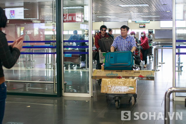 Ông bầu Hoàng Tuấn đẩy hành lý đi phía trước, Đan Trường đi phía sau. Nhác thấy bóng anh Bo, tất cả đều ồ lên, vỗ tay mừng rỡ.