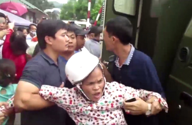 
Một phụ nữ đang bị cưỡng chế đưa lên xe đặc chủng của lực lượng công an
